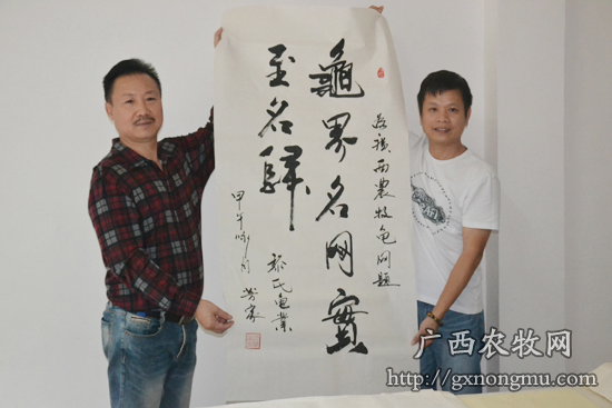 广西龟鳖协会副会长黎芳家（图左）为广西农牧龟鳖网题词