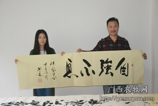 黎芳家(图左）为广西农牧网主创人员题词